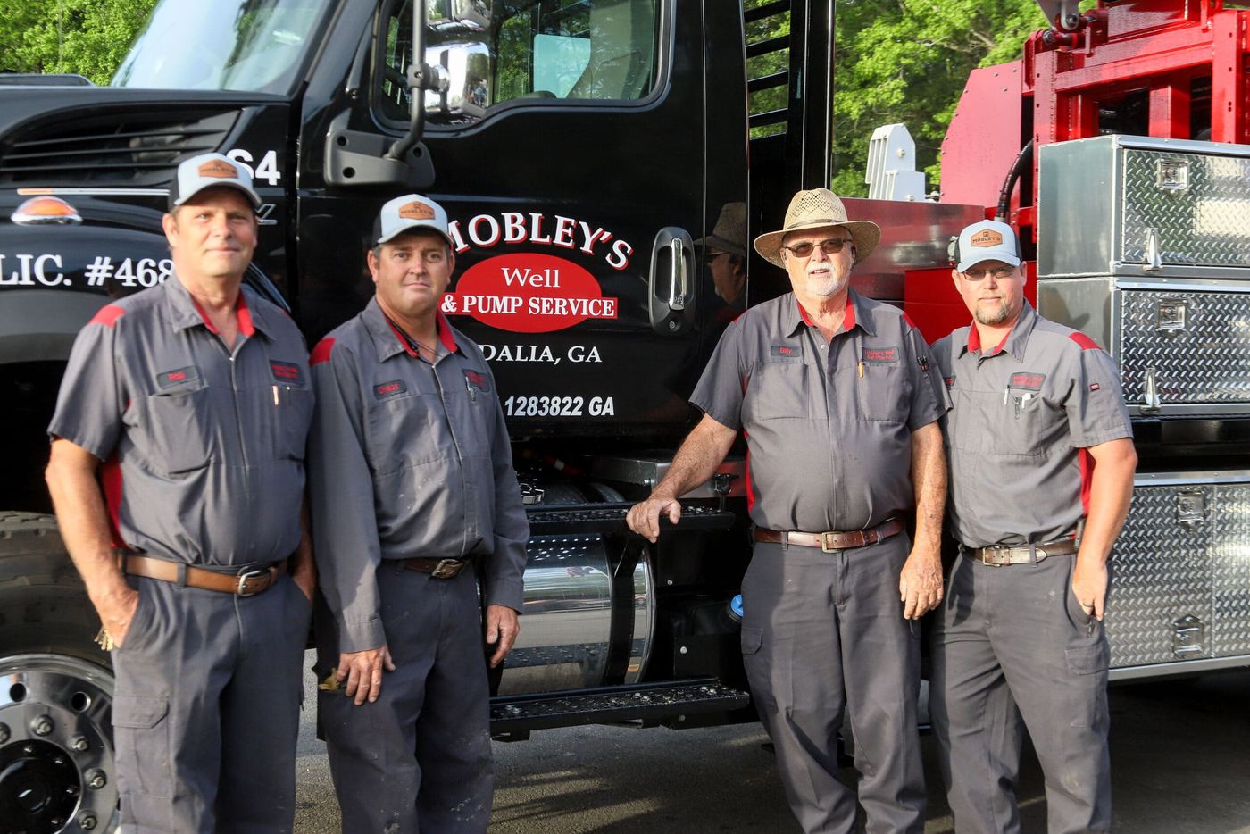 Four members of the Mobley's Well & Pump team in front of a service truck