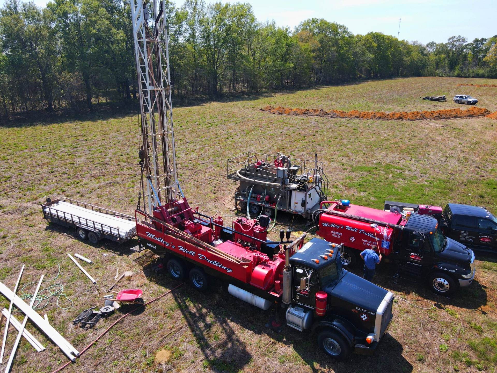 Aerial view of Mobley trucks drilling a well in a field