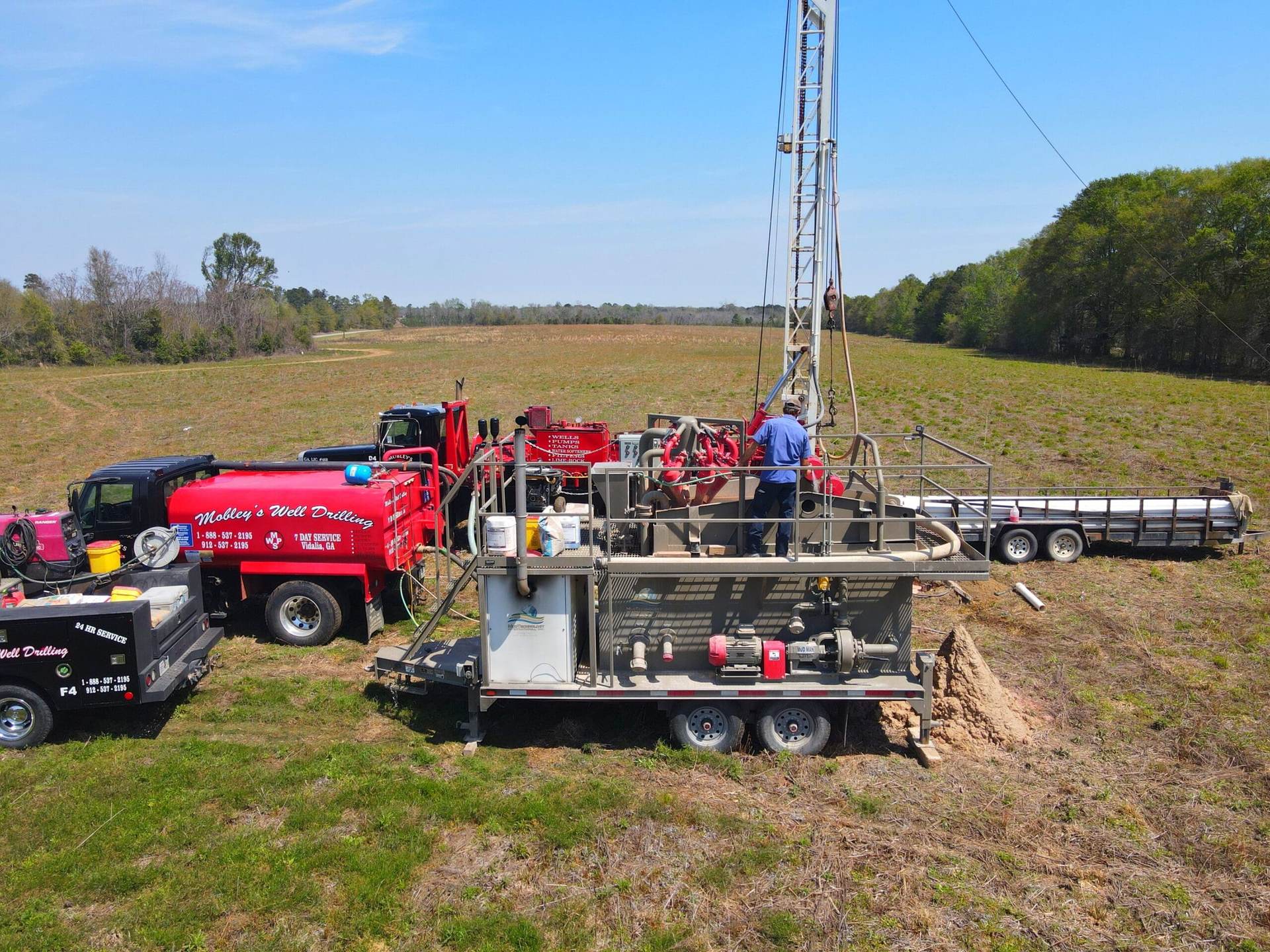 Mobley drill rig and service trucks at a well site