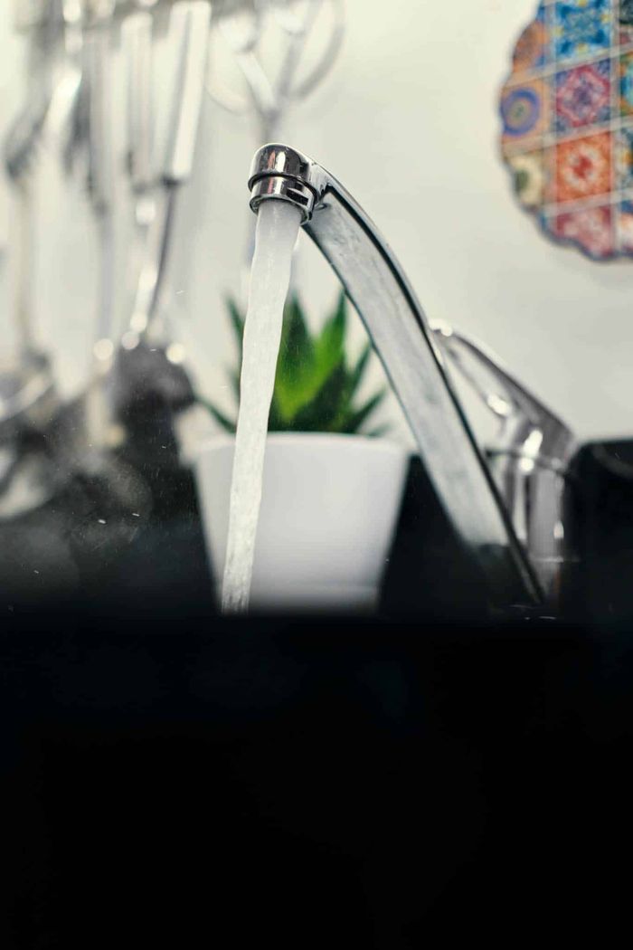 Modern kitchen faucet pouring water